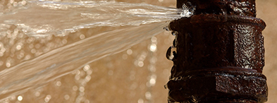 Damaged pipe spewing water | CNA Insurance