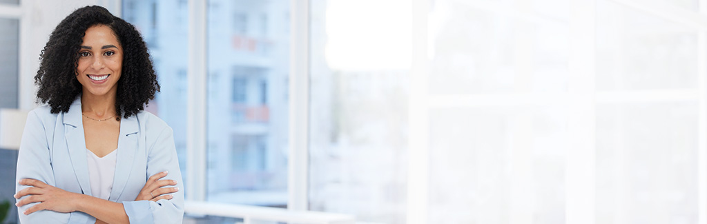 Woman standing in an office with arms crossed