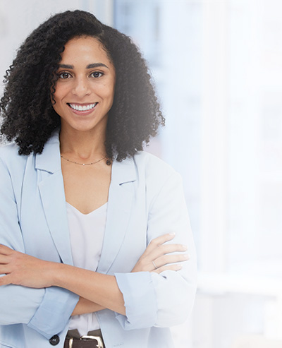 Woman standing in an office with arms crossed