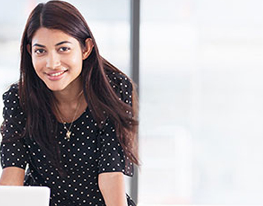 Woman smiling with laptop | CNA Insurance