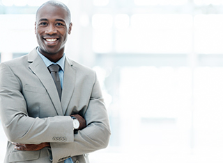 Man standing in an office with arms folded