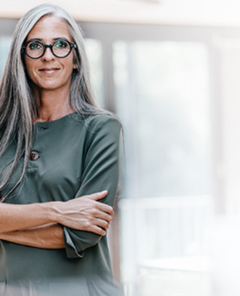 Woman standing in an office with arms crossed