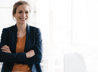 Woman standing in an office with her arms crossed