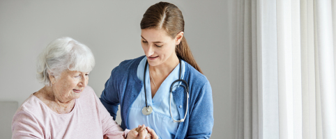 Nurse helping an elderly patient in a facility