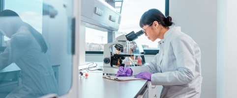 Scientist in a lab working with a microscope