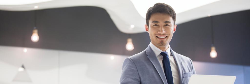 Businessman standing in an office holding a laptop