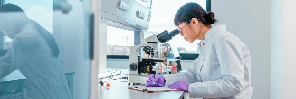 Scientist working in a lab over a microscope