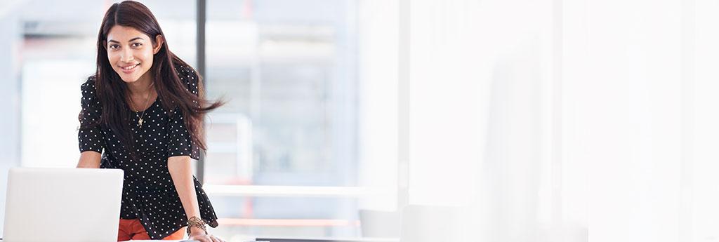 Woman smiling with laptop | CNA Insurance