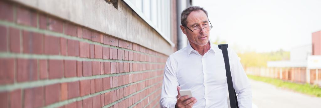 Man walking alongside a brick wall