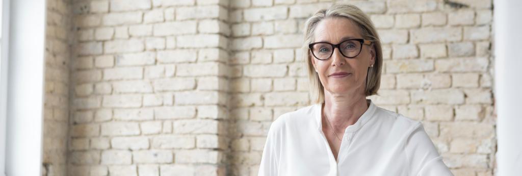 Woman with glasses sitting at a desk in an office