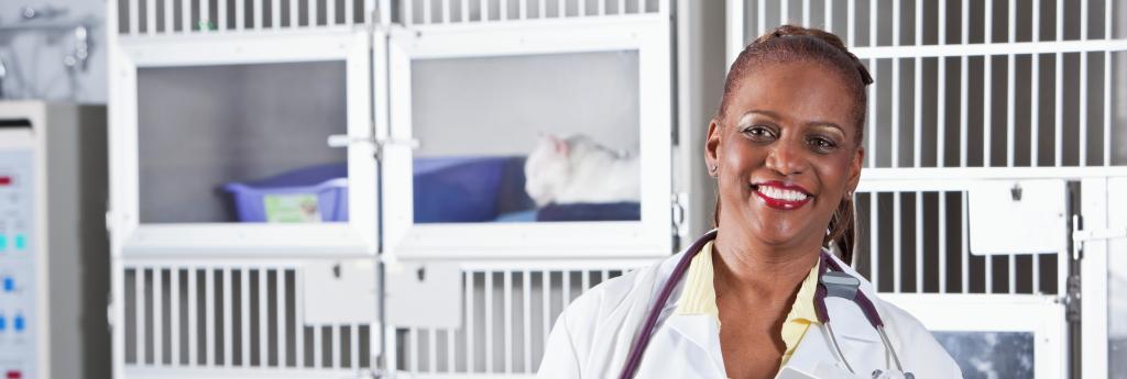 Veterinarian smiling and standing in front of kennels