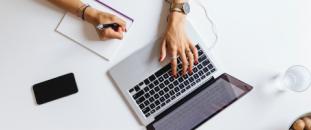 Hands typing on a laptop keyboard