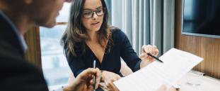 Two colleagues going over paperwork in an office