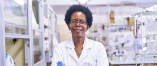 Female scientist standing in a lab with arms crossed