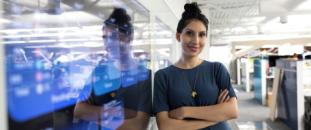 Woman in an office standing in front of a screen
