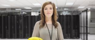 Woman standing in an office holding wires
