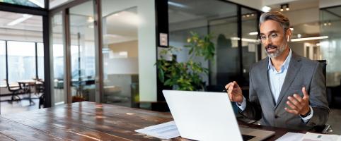 man smiling at laptop | CNA Insurance