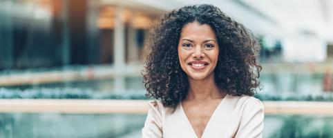Woman smiling in office building | CNA Insurance