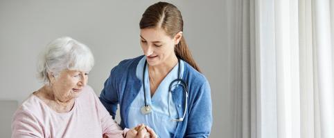 Nurse helping an elderly patient in a facility