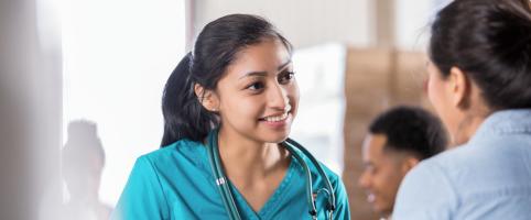 Nurse with a stethoscope talking with a patient in an office