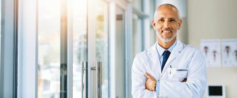Doctor standing in an office with his arms crossed