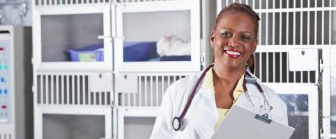 Female veterinarian standing in front of kennels