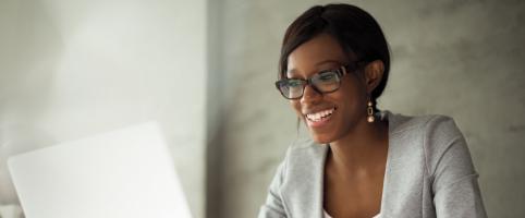Woman working at a desk in an office with a laptop