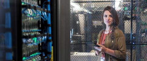 Woman standing in front of wires and holding a tablet