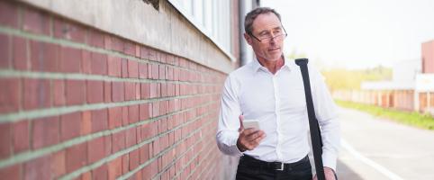 Man walking alongside a brick wall